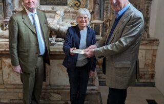 Chris receiving a gift and card from Roger Musson, Chair of Trustees, observed by our Patron Michael More-Molyneux, HM Lord-Lieutenant of Surrey, at the Loseley Chapel in St Nicolas Church, Guildford