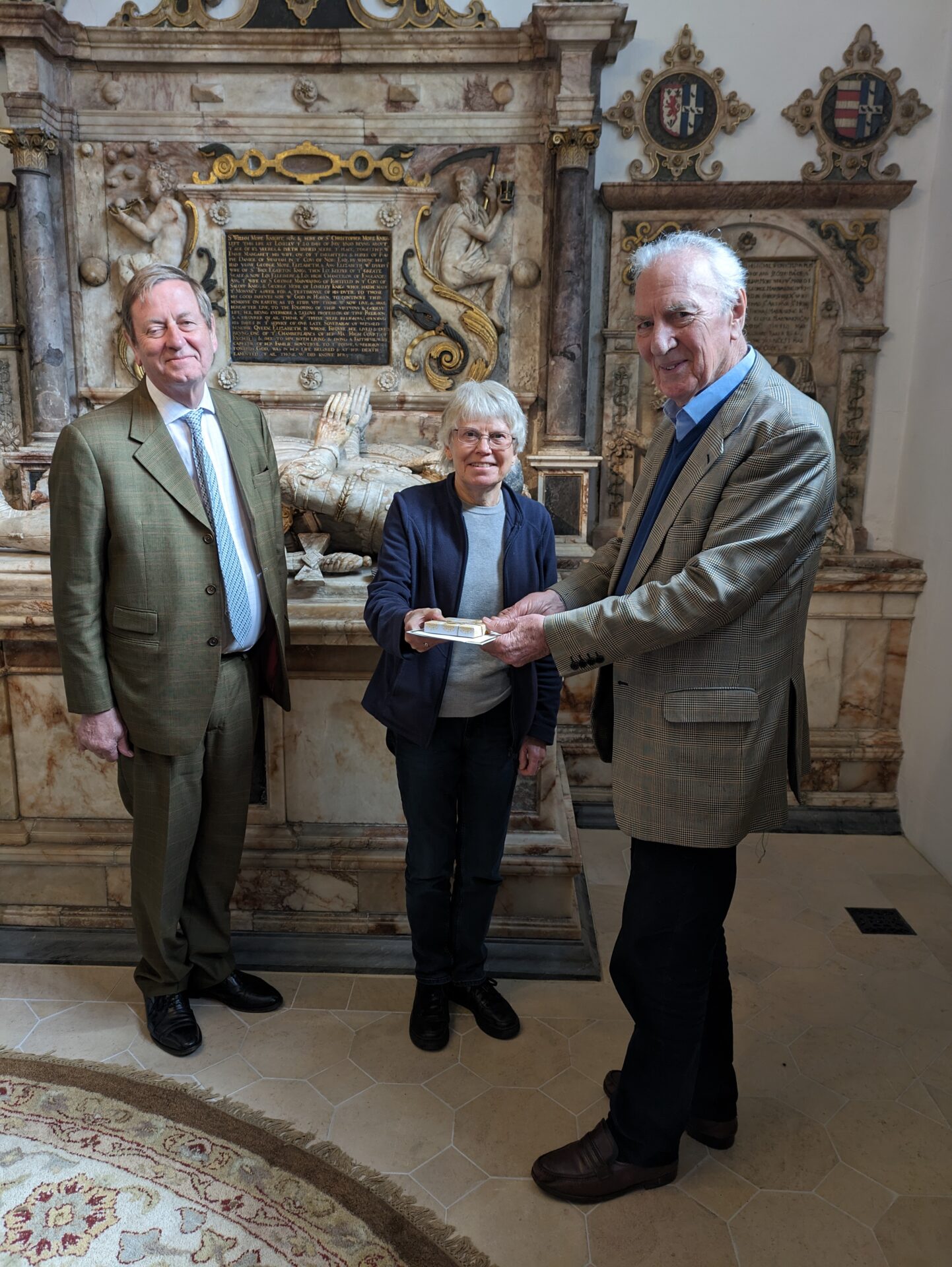 Chris receiving a gift and card from Roger Musson, Chair of Trustees, observed by our Patron Michael More-Molyneux, HM Lord-Lieutenant of Surrey, at the Loseley Chapel in St Nicolas Church, Guildford
